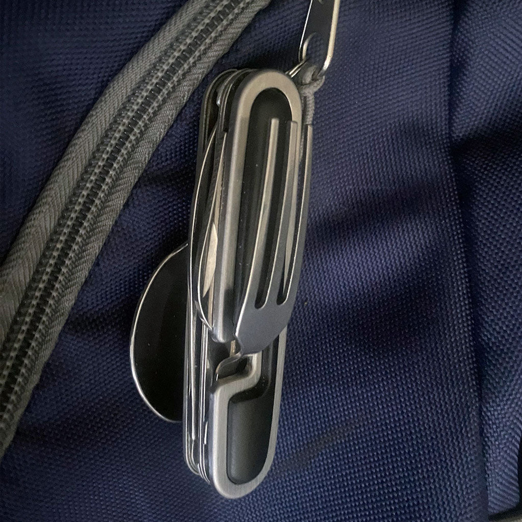 Clipped to the outside of a bag